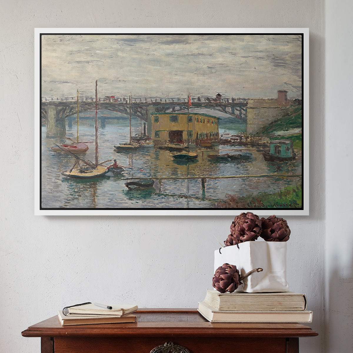 White floater framed canvas featuring Bridge at Argenteuil on a Gray Day, c. 1876 by Claude Monet above an entryway table in a minimalist foyer.