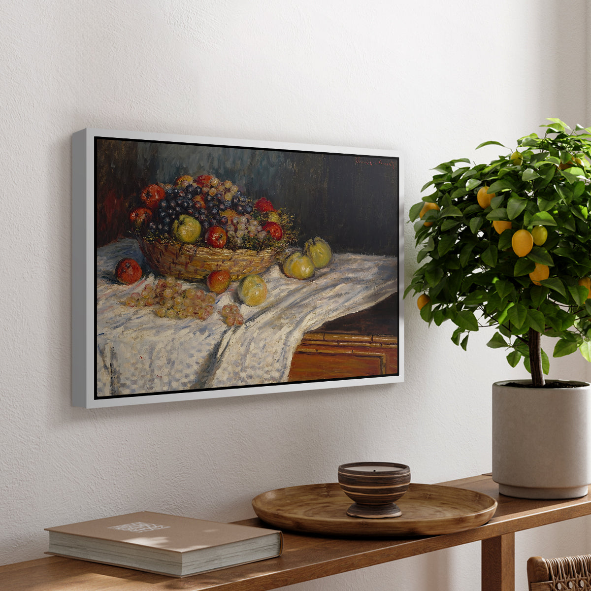 Still Life with Apples and Grapes, 1880 by Claude Monet, presented in a white floater framed canvas featuring an arrangement of apples and grapes on table with soft natural light, displayed above a hallway console table.
