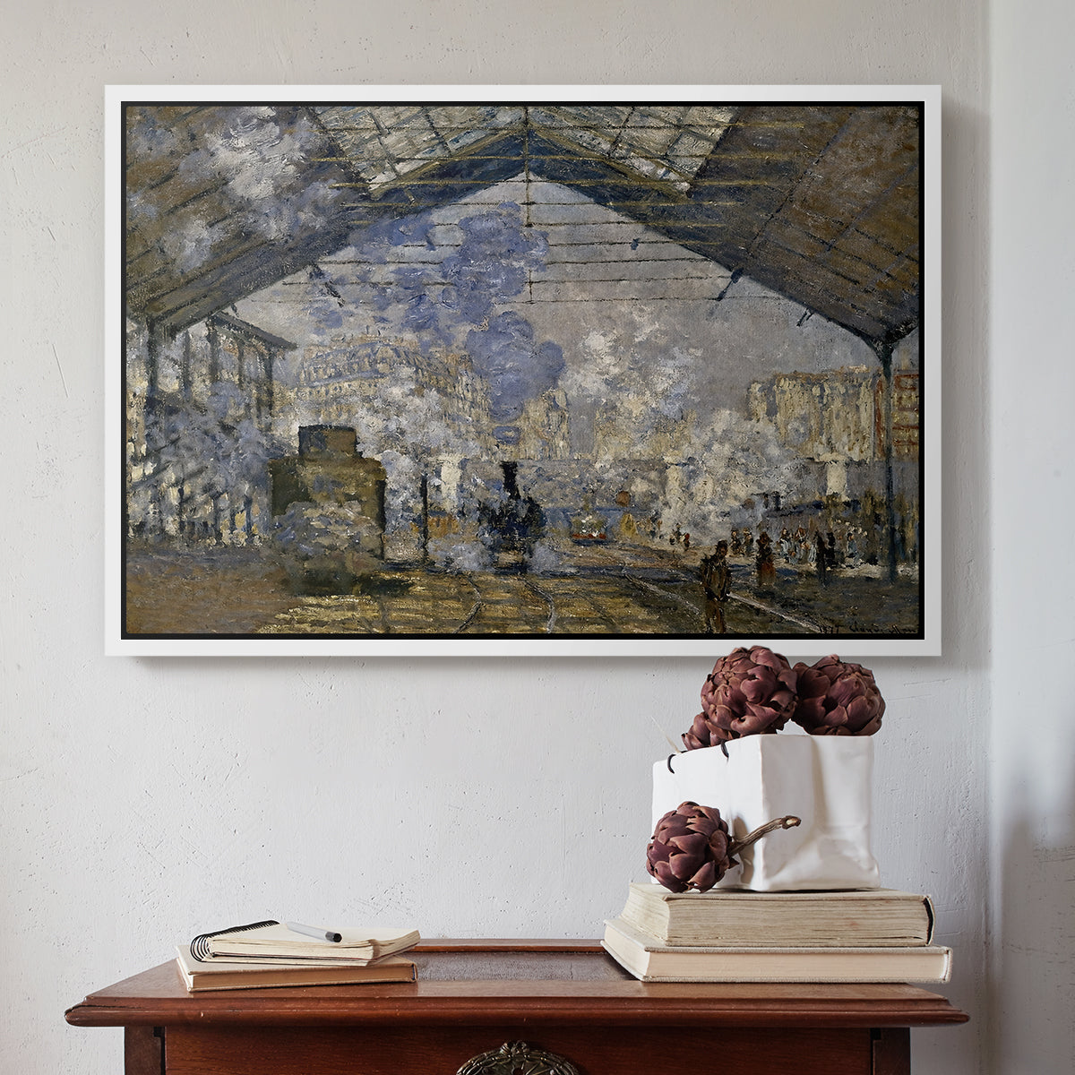 White floater framed canvas featuring The Gare Saint-Lazare, 1877 by Claude Monet above an entryway table in a minimalist foyer.