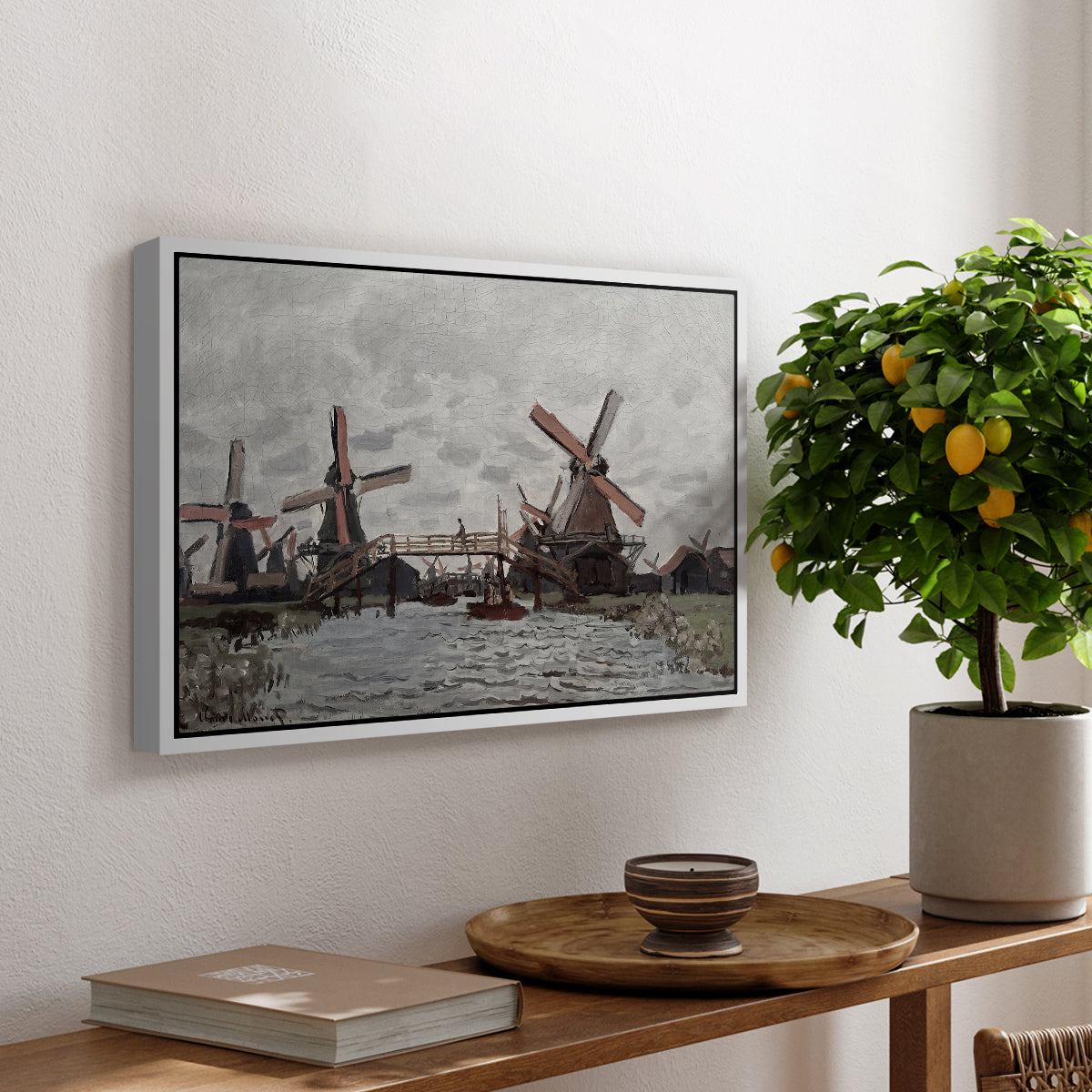 Windmills near Zaandam, 1871 by Claude Monet, presented in a white floater framed canvas featuring windmills standing beside water under open sky in rural landscape, displayed above a hallway console table.