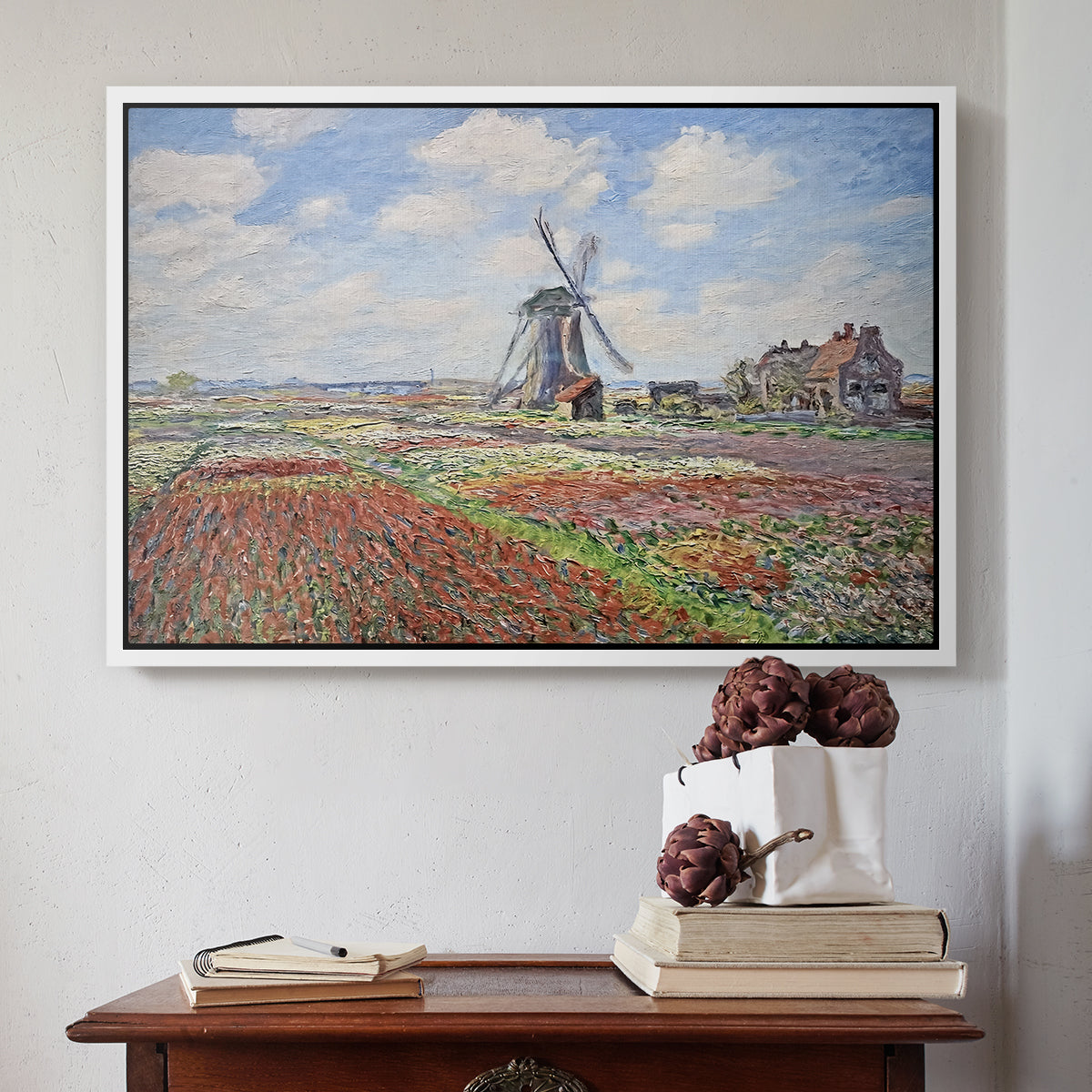 White floater framed canvas featuring Tulip Fields with the Rijnsburg Windmill, 1886 by Claude Monet above an entryway table in a minimalist foyer.