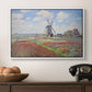 Tulip Fields with the Rijnsburg Windmill, 1886 by Claude Monet in a white floater framed canvas displayed above a console table in a hallway, featuring a rural scene with patterned rows of flowers and windmill.