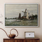 White floater framed canvas featuring a rustic scene with windmill and reflections in water, displayed above a cabinet in a soft-toned living room.
