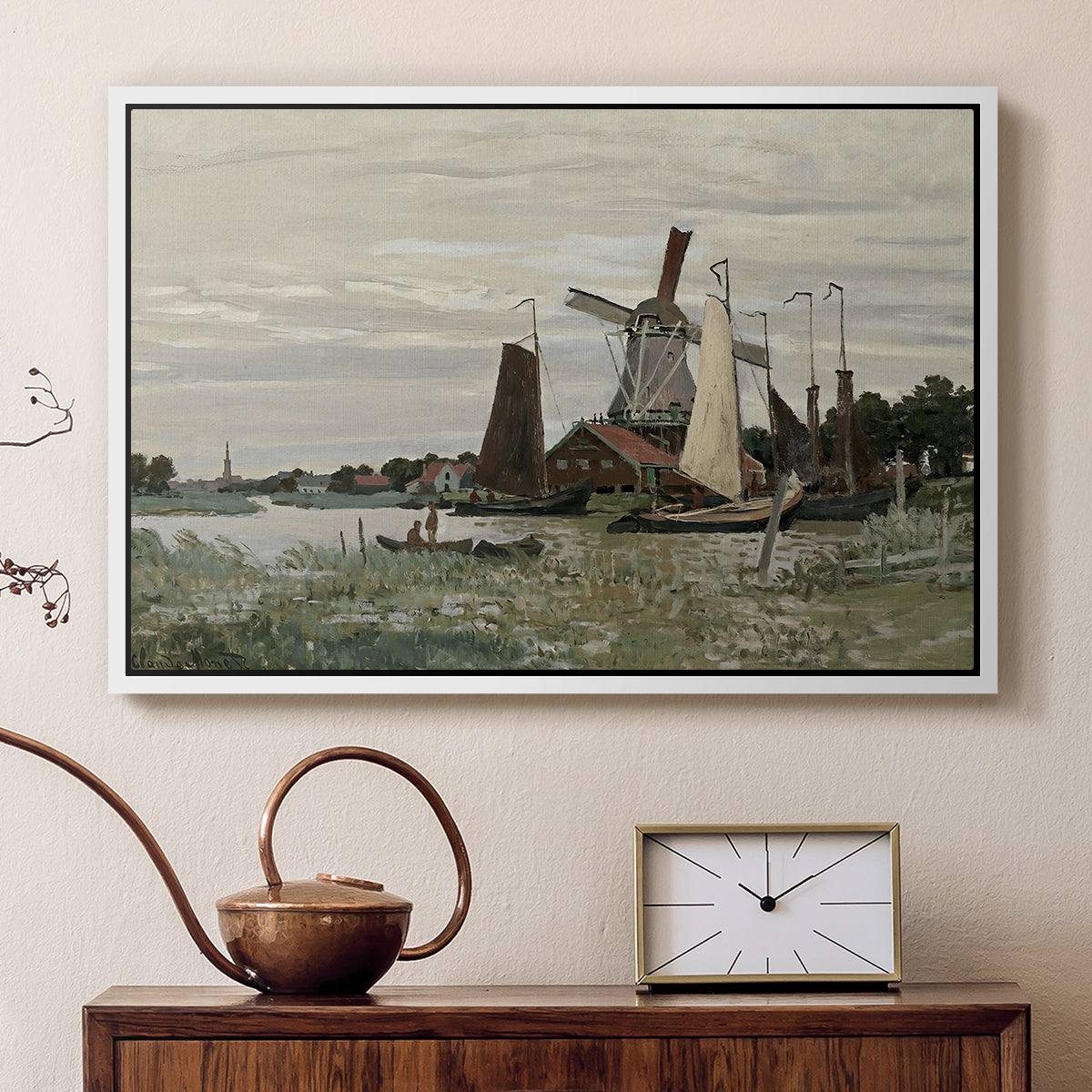 White floater framed canvas featuring a rustic scene with windmill and reflections in water, displayed above a cabinet in a soft-toned living room.