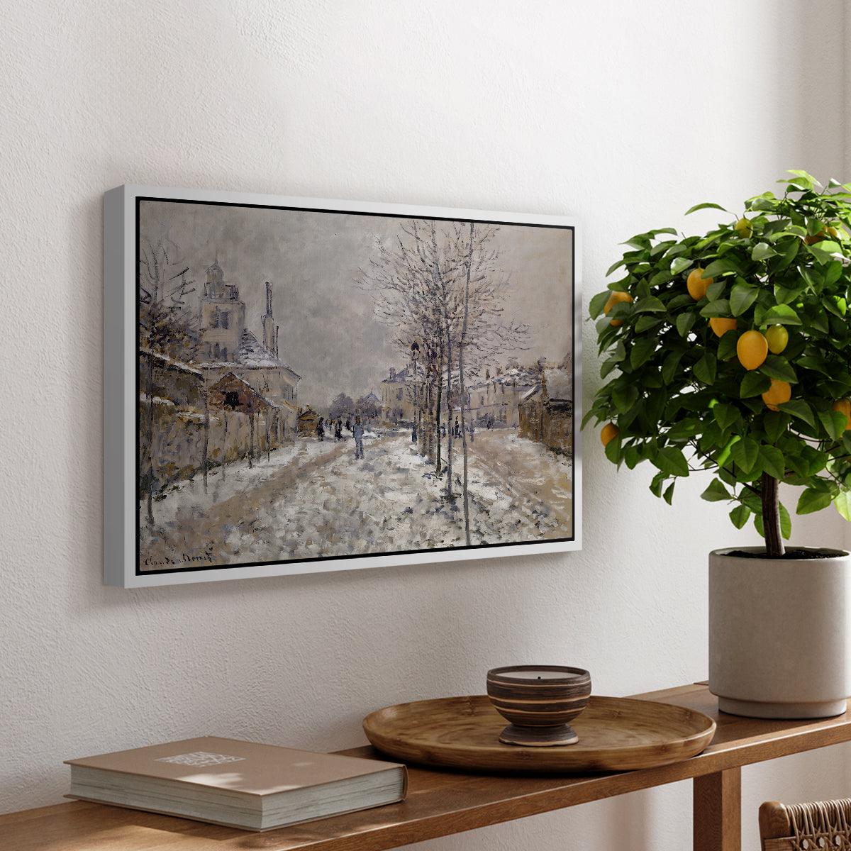 The Boulevard de Pontoise at Argenteuil, Snow Effect, 1875 by Claude Monet, presented in a white floater framed canvas featuring a snow-covered street lined with trees and buildings under winter sky, displayed above a hallway console table.