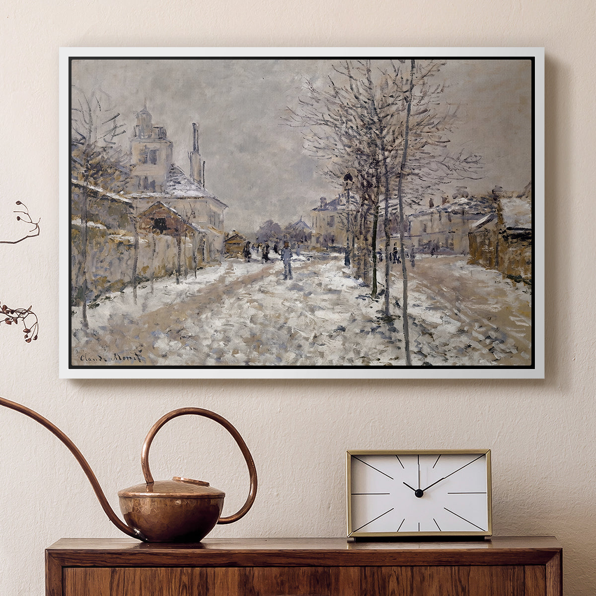 White floater framed canvas featuring a quiet boulevard blanketed in snow with distant figures, displayed above a cabinet in a soft-toned living room.