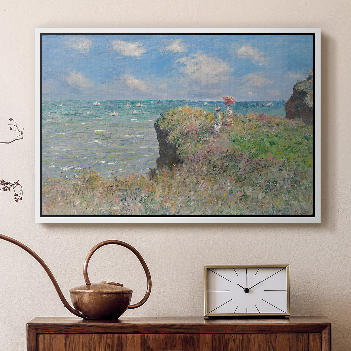 White floater framed canvas featuring a coastal cliff scene with grass, wind, and expansive sea view, displayed above a cabinet in a soft-toned living room.