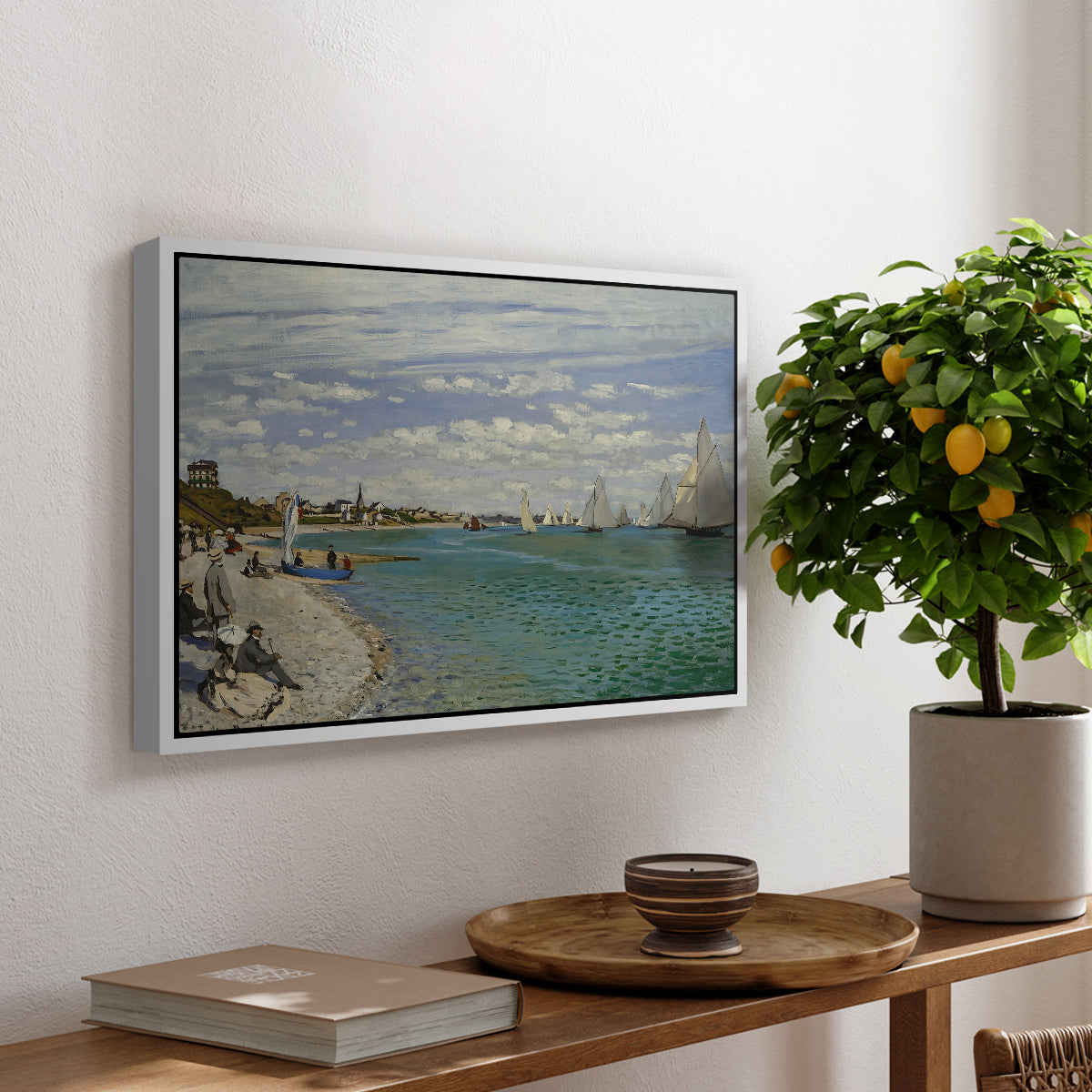 Regatta at Sainte-Adresse, 1867 by Claude Monet, presented in a white floater framed canvas featuring sailboats gathered near shore with flags and spectators along coastline, displayed above a hallway console table.