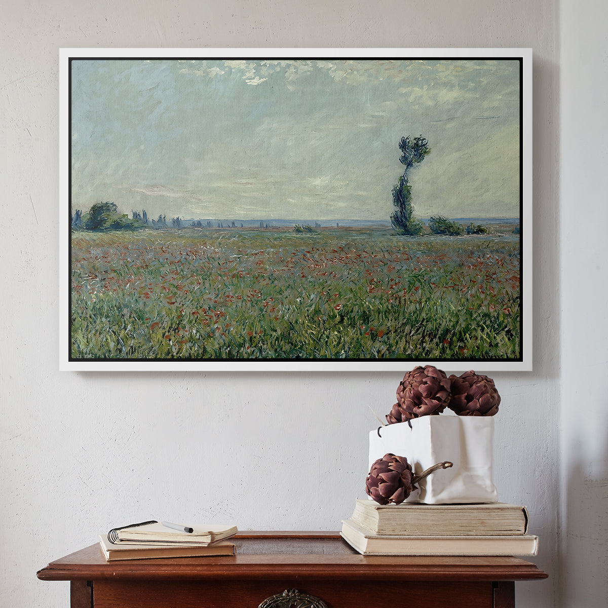 White floater framed canvas featuring Poppy Field, 1881 by Claude Monet above an entryway table in a minimalist foyer.