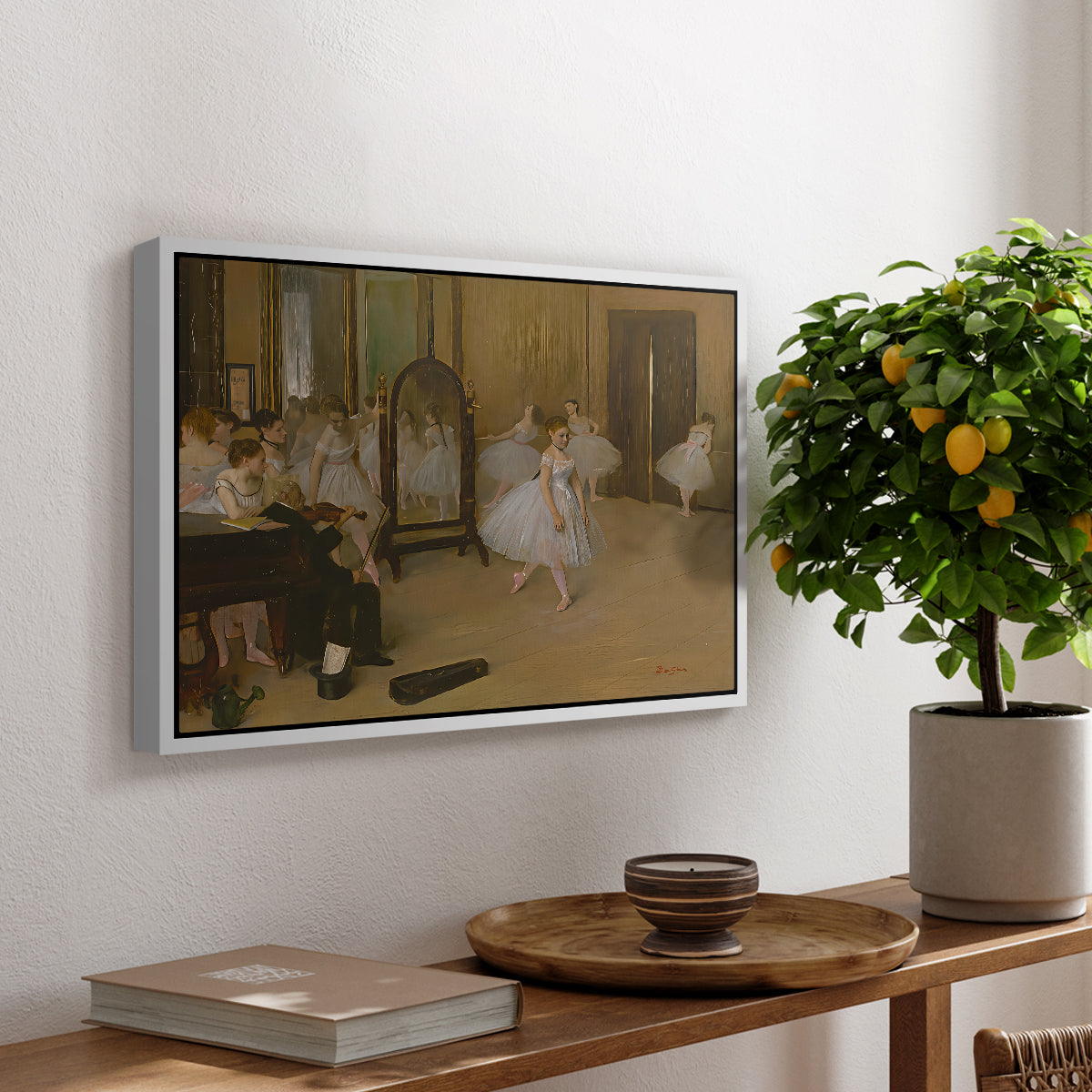 The Dancing Class, c. 1870 by Edgar Degas, presented in a white floater framed canvas featuring a ballet class with dancers practicing positions under instructor guidance, displayed above a hallway console table.