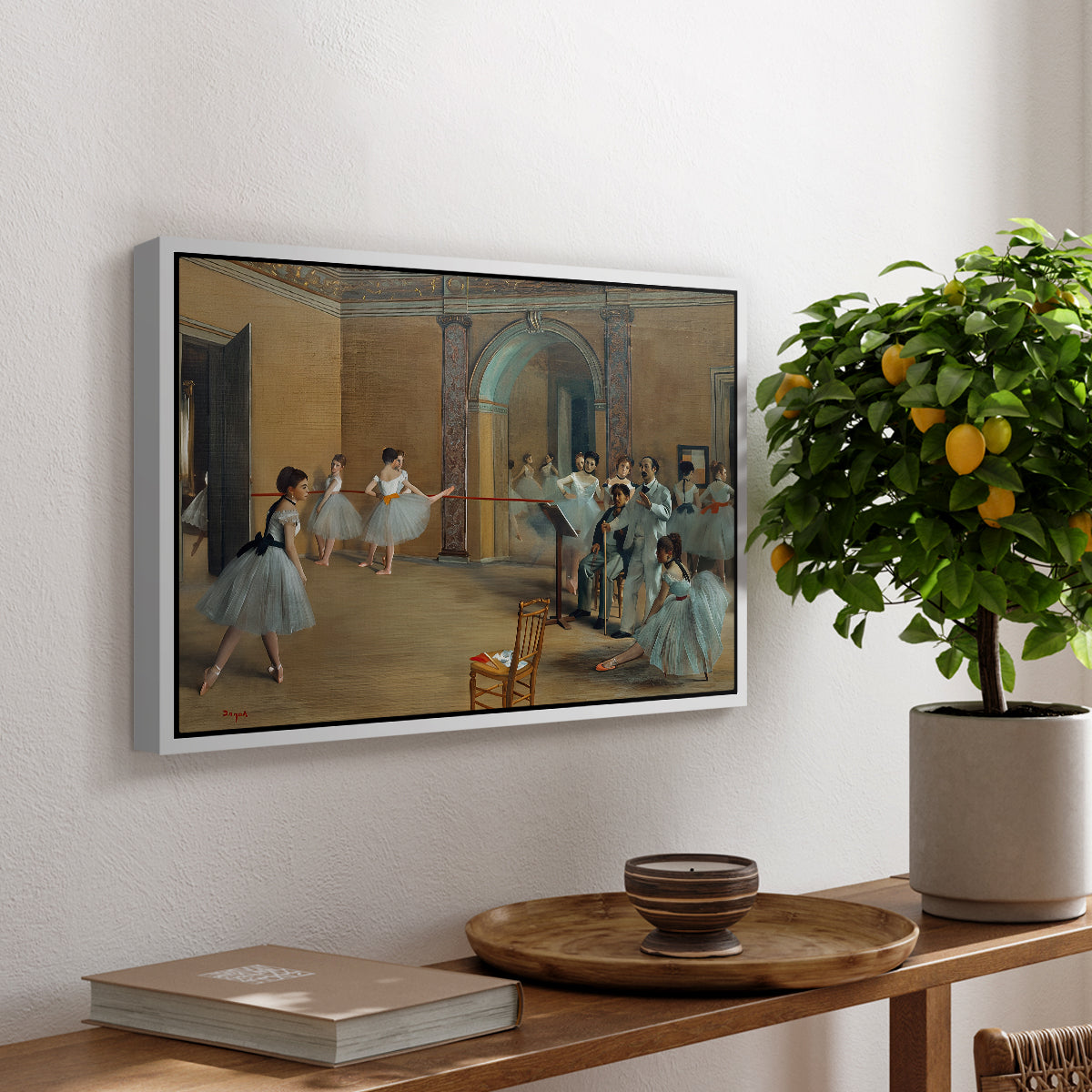 The Dance Foyer at the Opera on the Rue Le Peletier, 1872 by Edgar Degas, presented in a white floater framed canvas featuring ballet dancers gathered in rehearsal hall with mirrors and columns, displayed above a hallway console table.