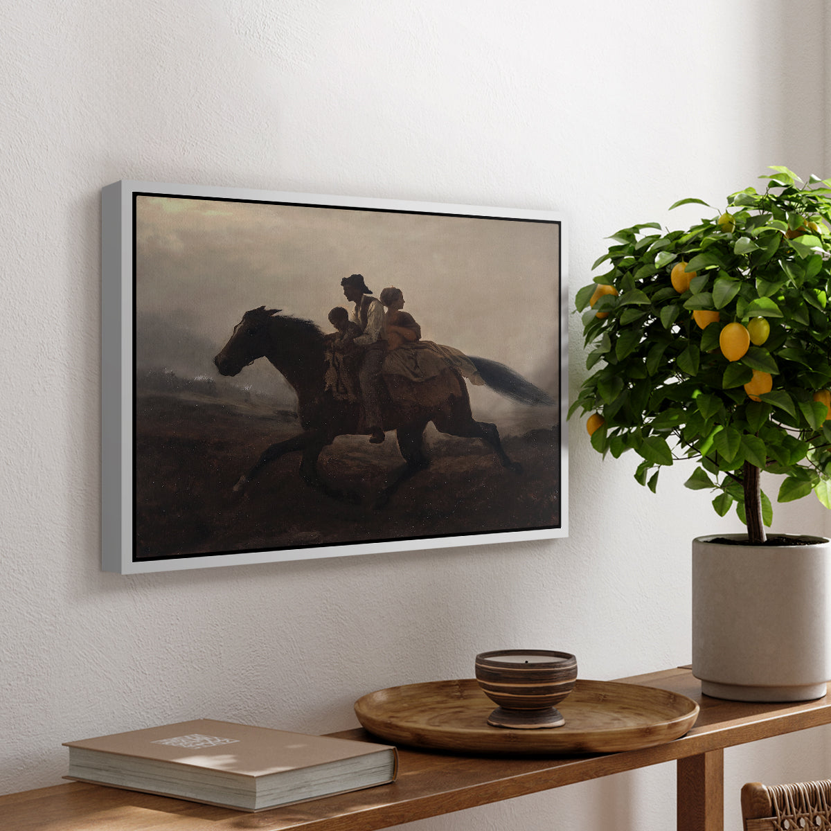 A Ride for Liberty – The Fugitive Slaves, c. 1862 by Eastman Johnson, presented in a white floater framed canvas featuring a family riding horseback through night escaping across landscape, displayed above a hallway console table.