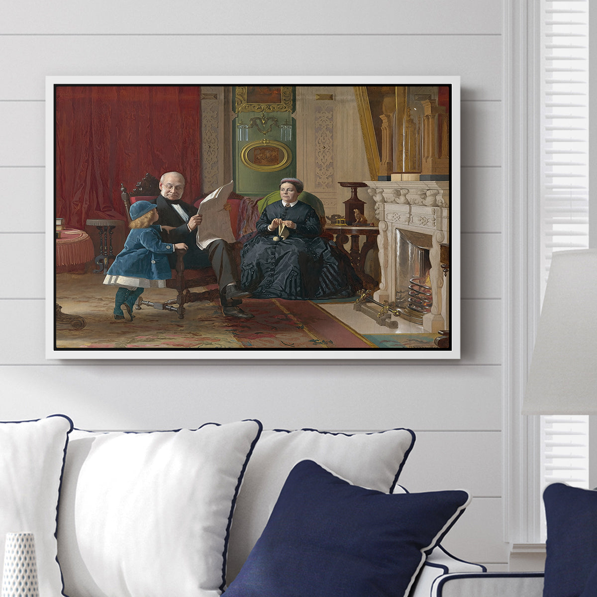 The Brown Family, 1869 by Eastman Johnson displayed above a sofa in a living room in a white floater frame, featuring a domestic portrait of group gathered in modest home setting.