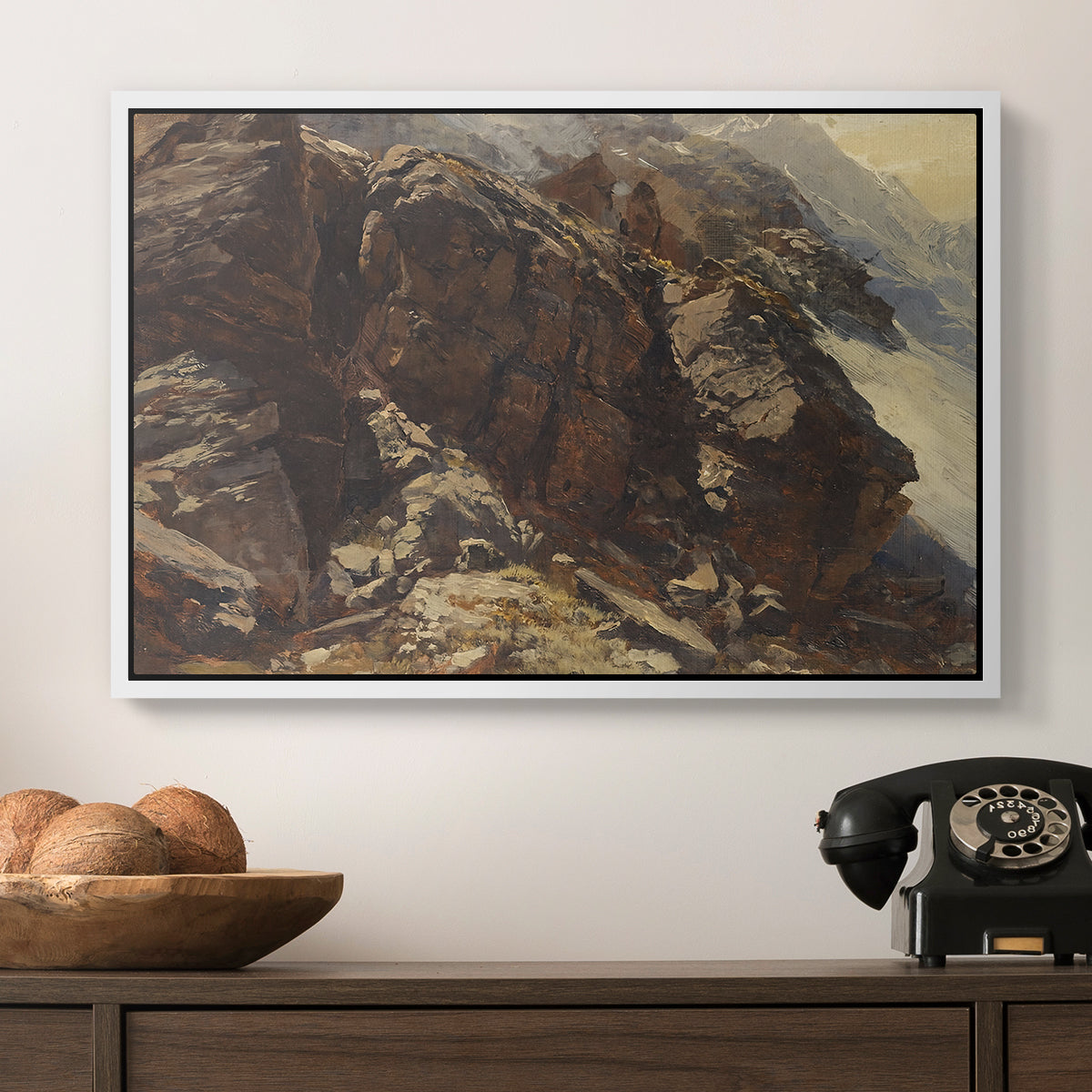 High Mountain Study, c. 1870 by Edward Theodore Compton in a white floater framed canvas displayed above a console table in a hallway, featuring a realistic depiction of mountainous terrain under open sky.