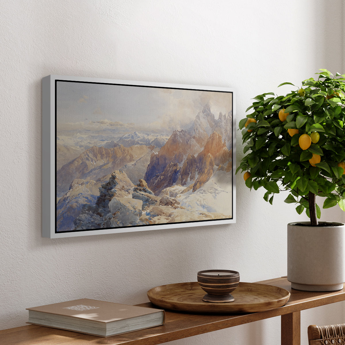 Col du Géant, 1903 by Edward Theodore Compton, presented in a white floater framed canvas featuring a mountain pass with snow-covered peaks and expansive alpine valley, displayed above a hallway console table.
