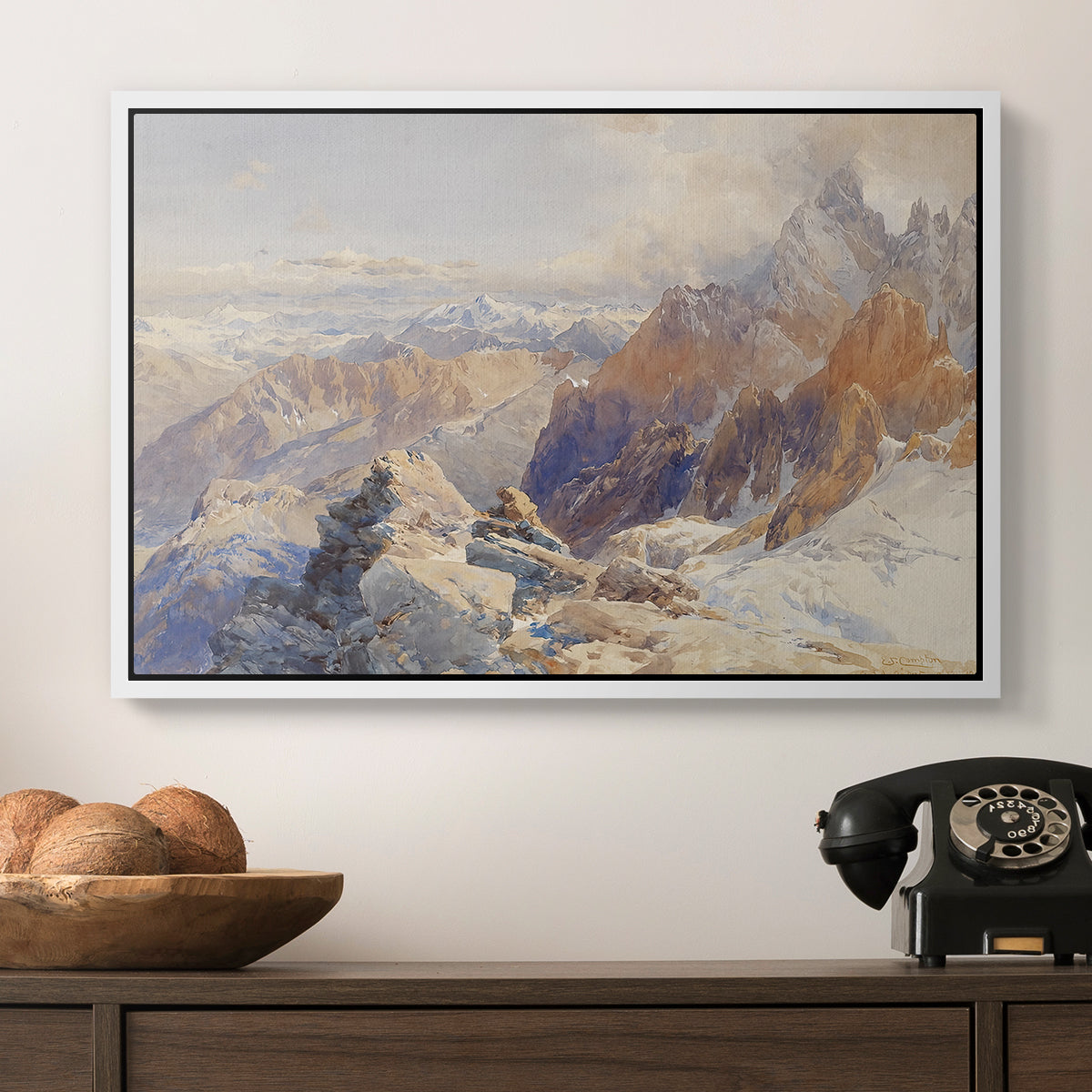 Col du Géant, 1903 by Edward Theodore Compton in a white floater framed canvas displayed above a console table in a hallway, featuring a rugged mountain pass scene with distant peaks.