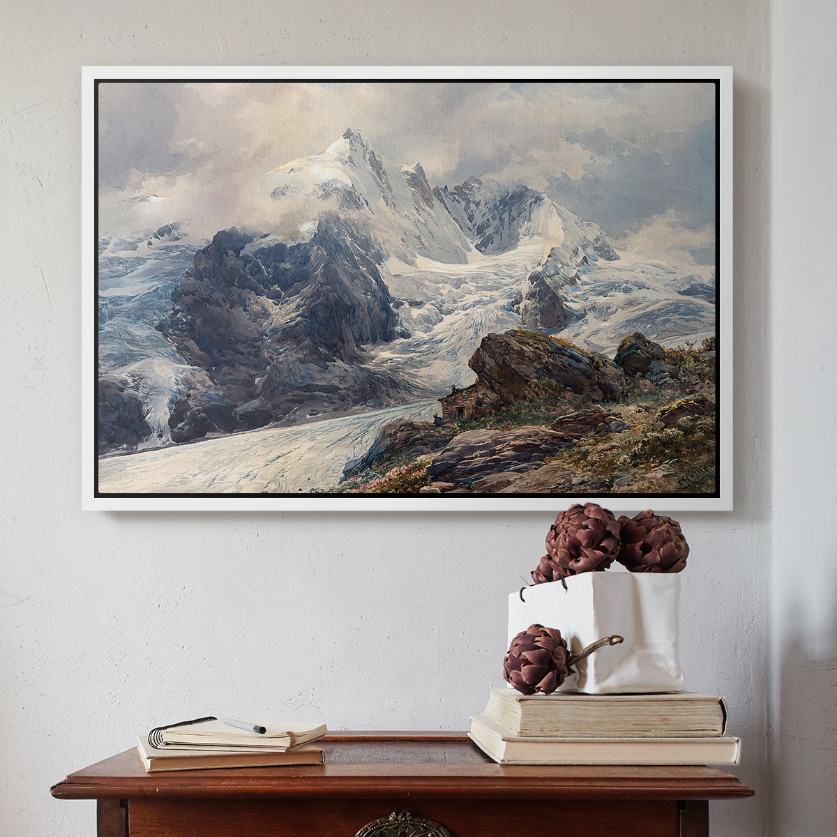 White floater framed canvas featuring The Grossglockner, 1880 by Edward Theodore Compton above an entryway table in a minimalist foyer.