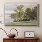 White floater framed canvas featuring a natural setting with water, trees, and open sky, displayed above a cabinet in a soft-toned living room.