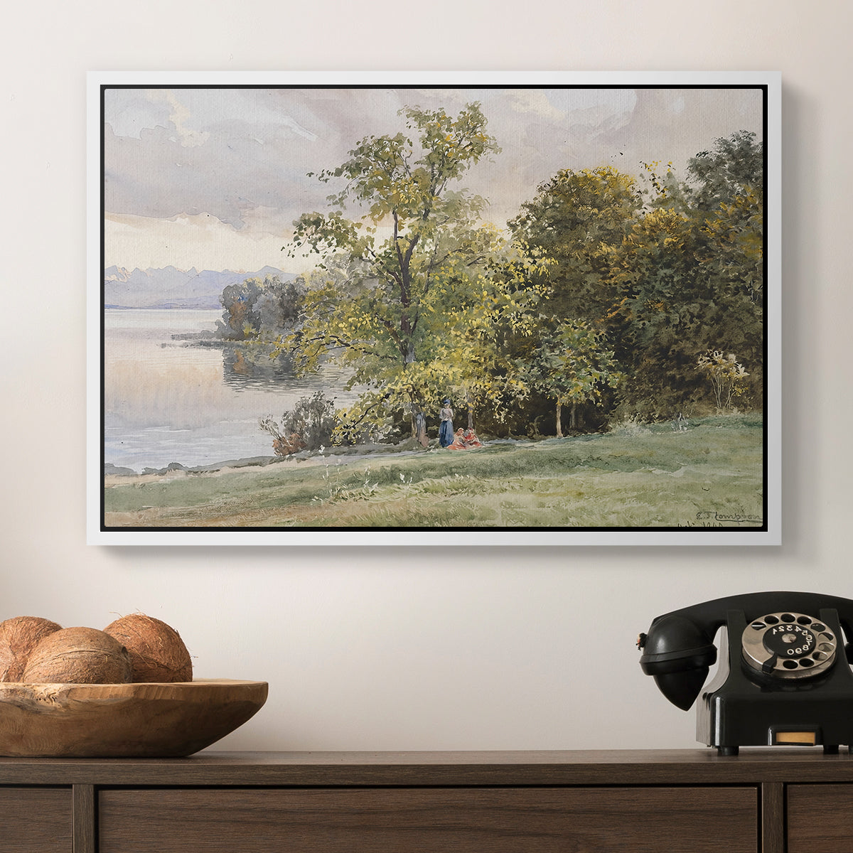 Landscape at Lake Starnberg, 1890 by Edward Theodore Compton in a white floater framed canvas displayed above a console table in a hallway, featuring a tranquil lakeside view with soft atmospheric tones.