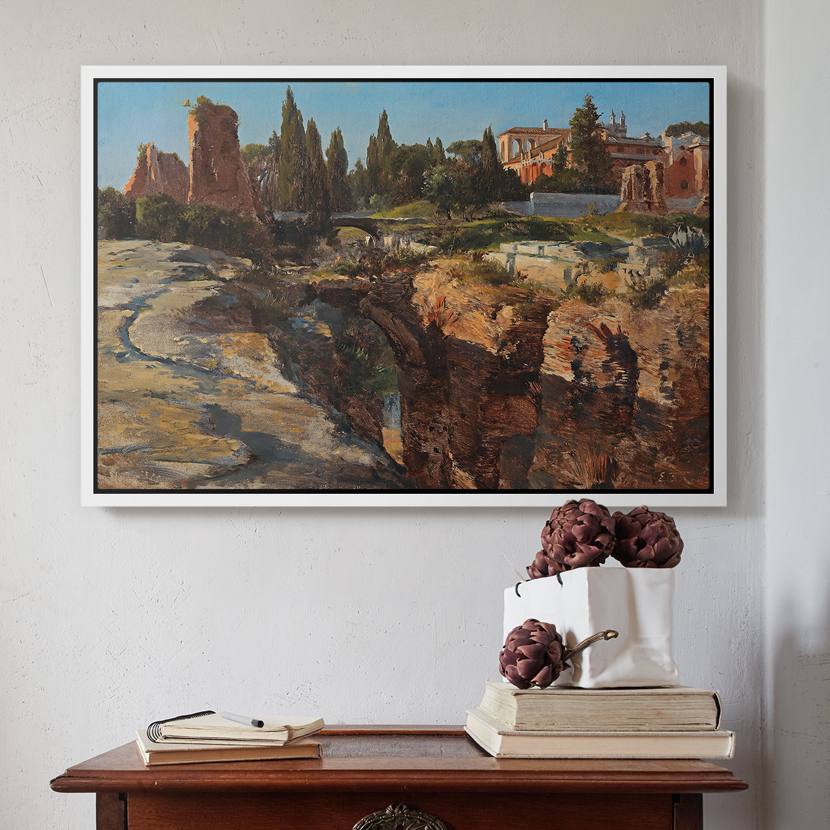 White floater framed canvas featuring Palatine in Rome, c. 1921 by Edward Theodore Compton above an entryway table in a minimalist foyer.