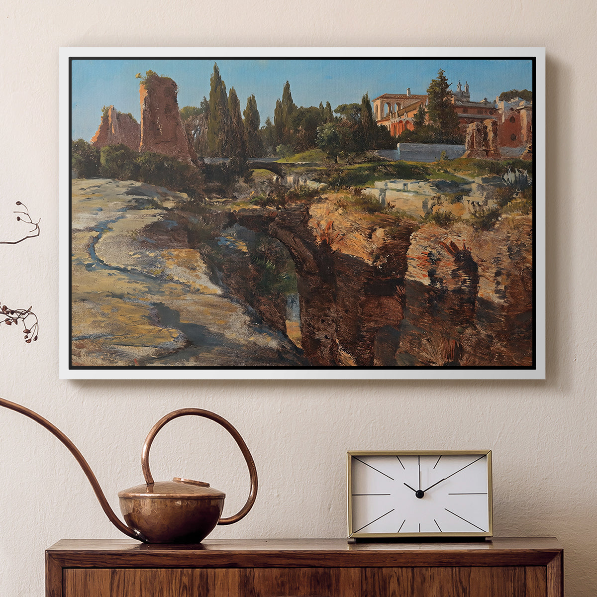 White floater framed canvas featuring a cityscape with classical ruins and surrounding terrain, displayed above a cabinet in a soft-toned living room.