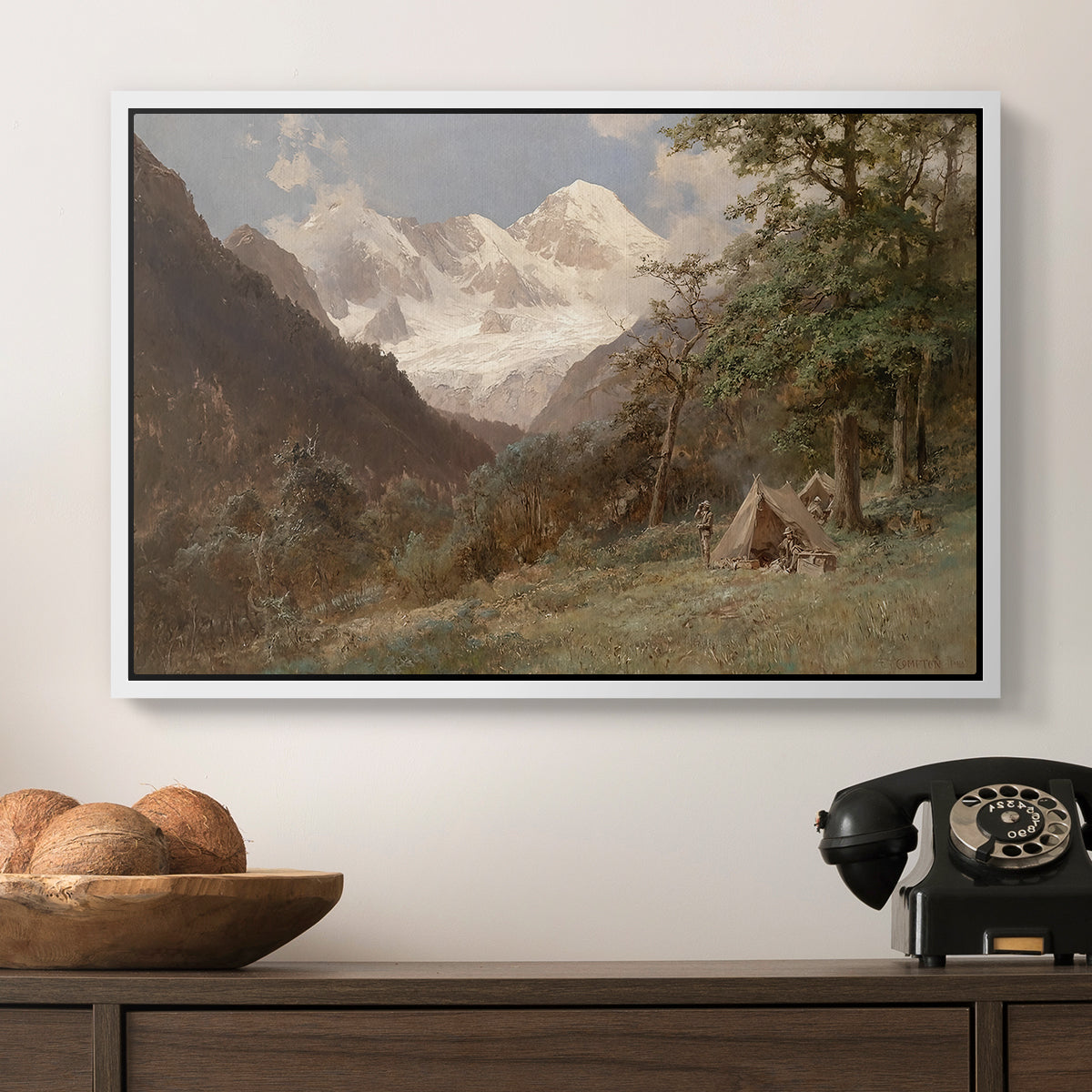 Landscape in the Caucasus, c. 1921 by Edward Theodore Compton in a white floater framed canvas displayed above a console table in a hallway, featuring a realistic depiction of remote mountain environment.