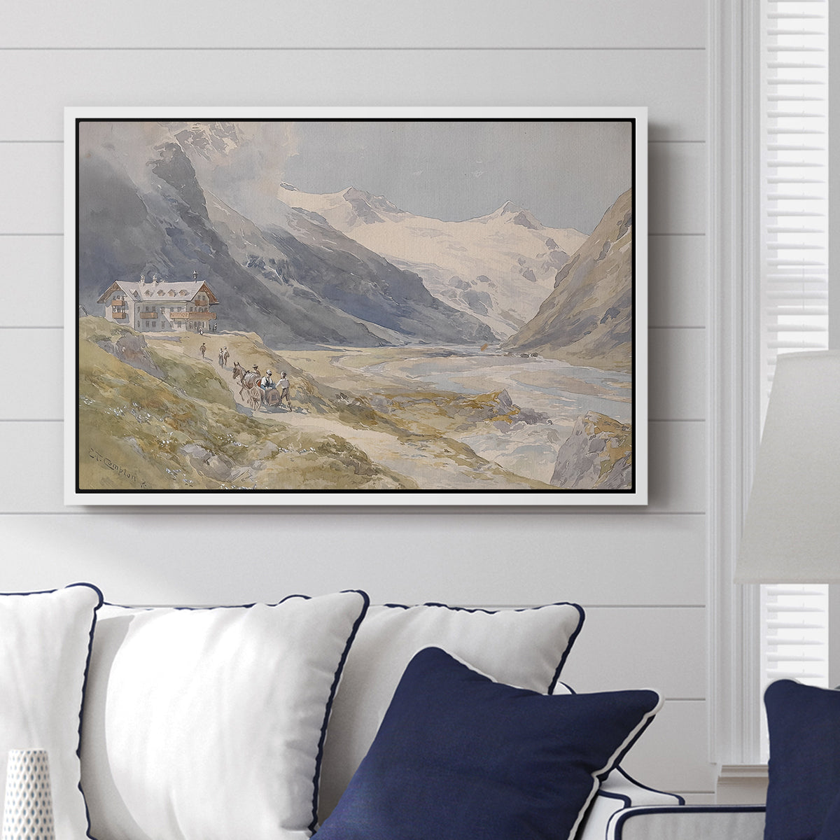 Shepherds (Pasterze), c. 1921 by Edward Theodore Compton displayed above a sofa in a living room in a white floater frame, featuring a pastoral mountain scene with figures tending livestock.