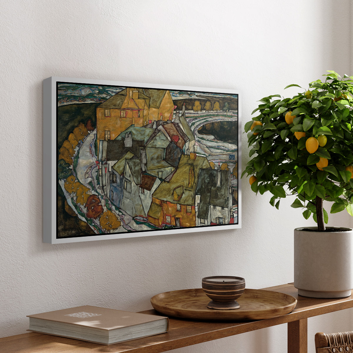 Crescent of Houses II (Island Town), 1915 by Egon Schiele, presented in a white floater framed canvas featuring a curved row of colorful houses forming crescent shape along water, displayed above a hallway console table.
