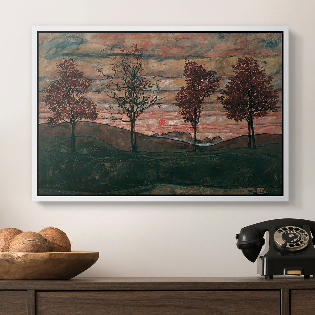 Four Trees, 1917 by Egon Schiele in a white floater framed canvas displayed above a console table in a hallway, featuring an expressionist landscape featuring isolated trees in field.