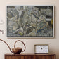 White floater framed canvas featuring an abstracted town view with angular rooftops and fragmented forms, displayed above a cabinet in a soft-toned living room.