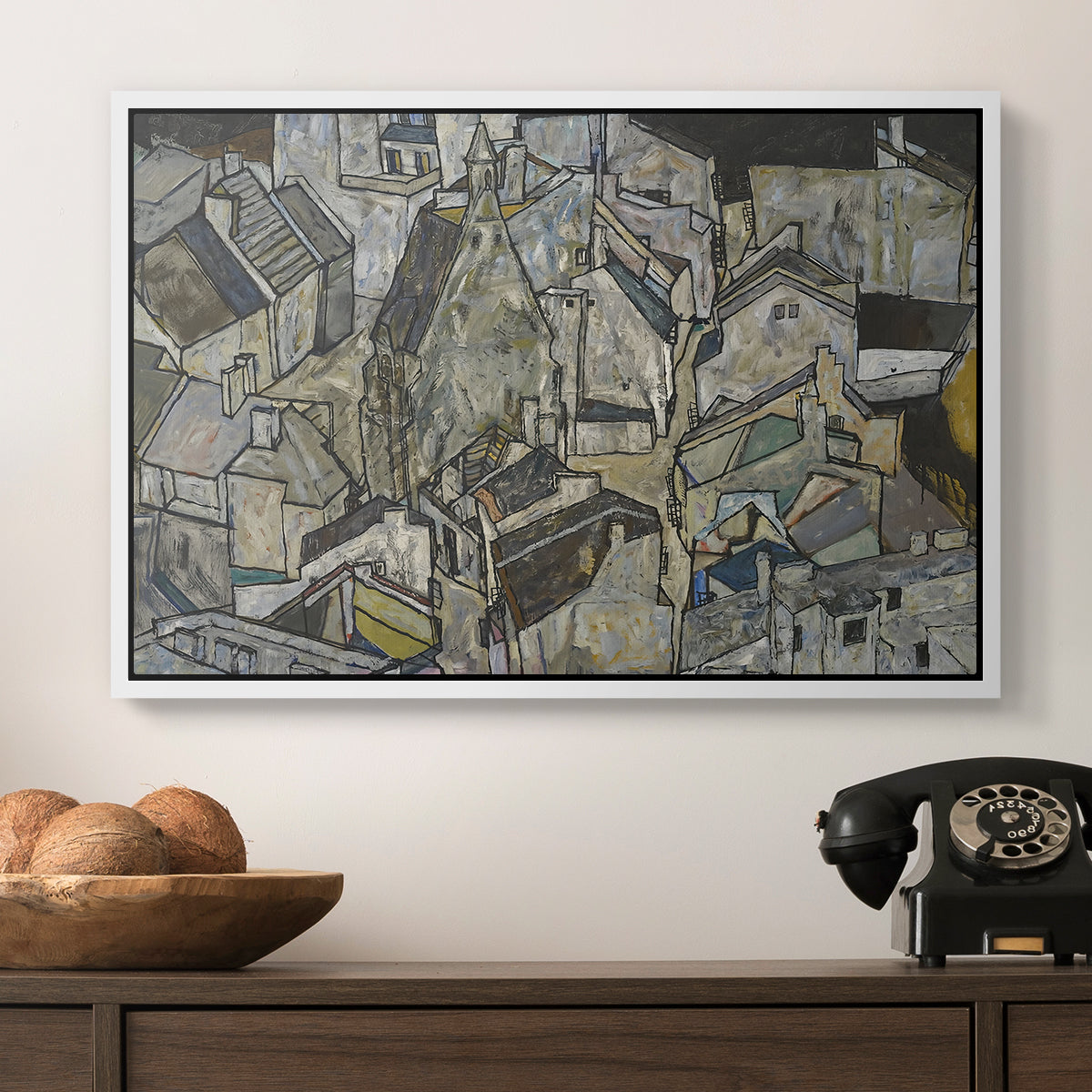 Mödling II, 1918 by Egon Schiele in a white floater framed canvas displayed above a console table in a hallway, featuring a stylized urban composition with geometric structures and muted tones.
