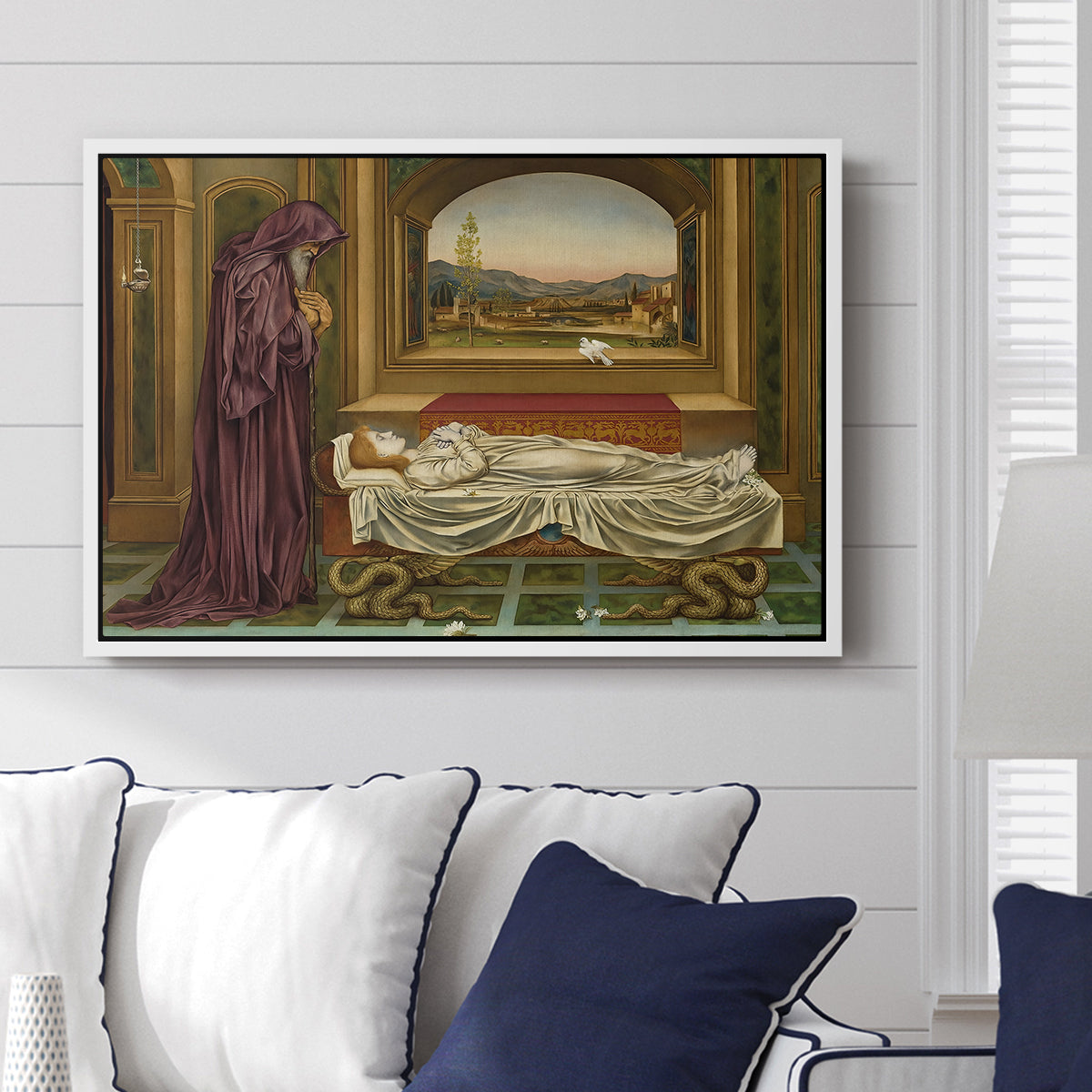 The Wandering Jew: Whom the Gods Love Die Young, 1888 by Evelyn De Morgan displayed above a sofa in a living room in a white floater frame, featuring a symbolic portrait of wandering figure in quiet architectural setting.