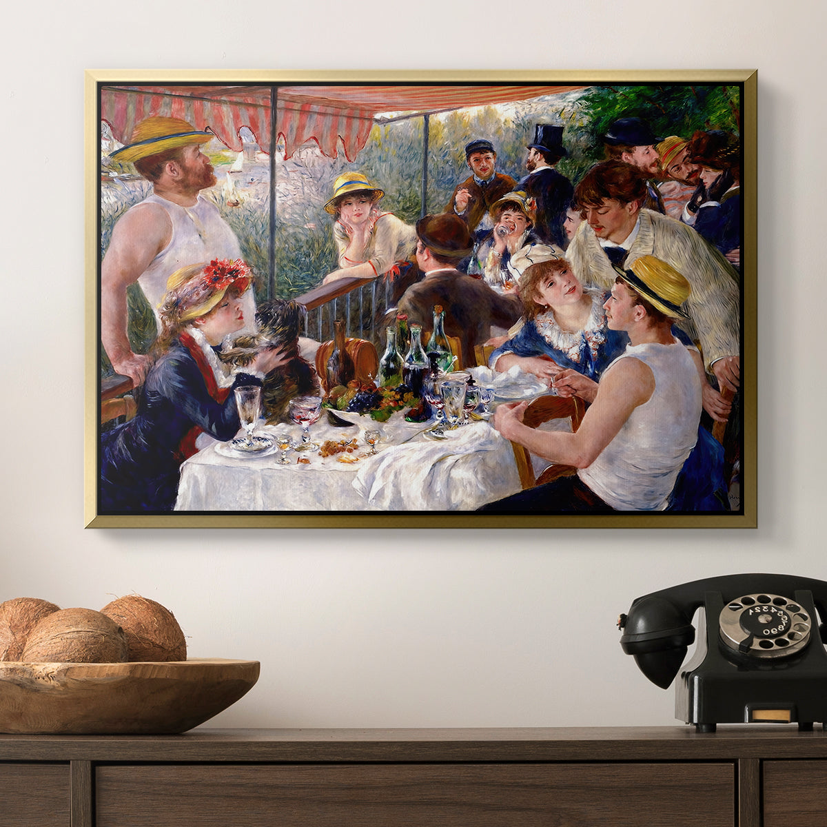 Luncheon of the Boating Party (Le Déjeuner des canotiers), 1880-1881 by Pierre-Auguste Renoir in a gold floater framed canvas displayed above a console table in a hallway, featuring a social dining scene with figures seated around table on riverside terrace.
