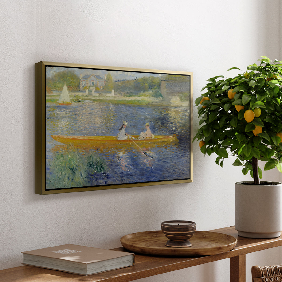 The Skiff (La Yole), 1875 by Pierre-Auguste Renoir, presented in a gold floater framed canvas featuring two figures seated in a small boat drifting across calm water, displayed above a hallway console table.