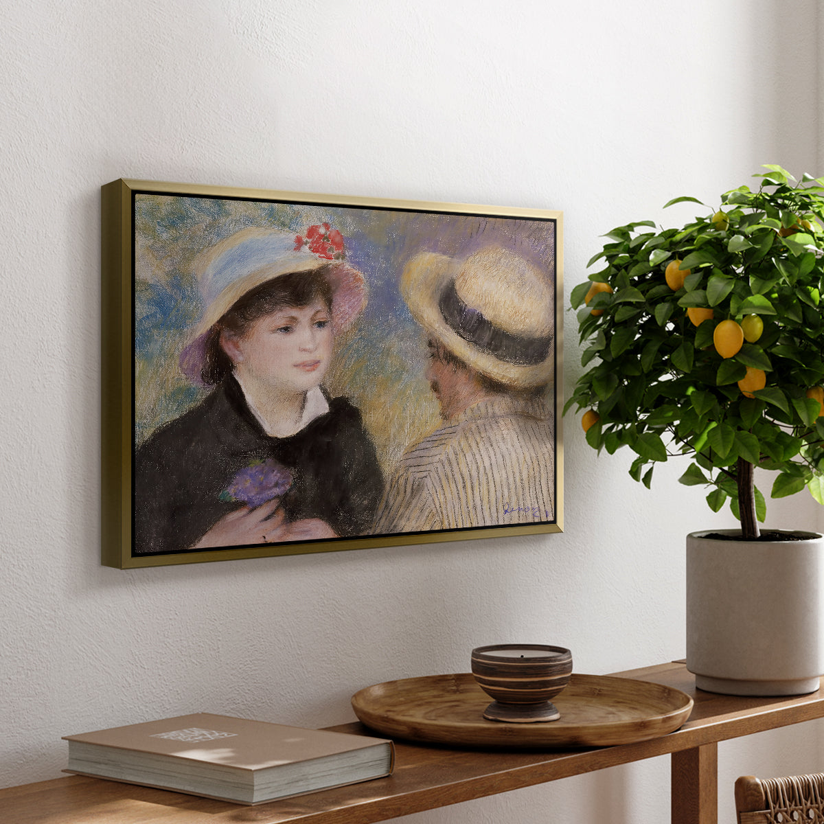 Boating Couple (Aline Charigot and Renoir), c. 1881 by Pierre-Auguste Renoir, presented in a gold floater framed canvas featuring a close-up of a couple seated together outdoors with hats and soft sunlight, displayed above a hallway console table.