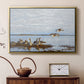Gold floater framed canvas featuring a realistic wildlife scene of geese in calm outdoor environment, displayed above a cabinet in a soft-toned living room.