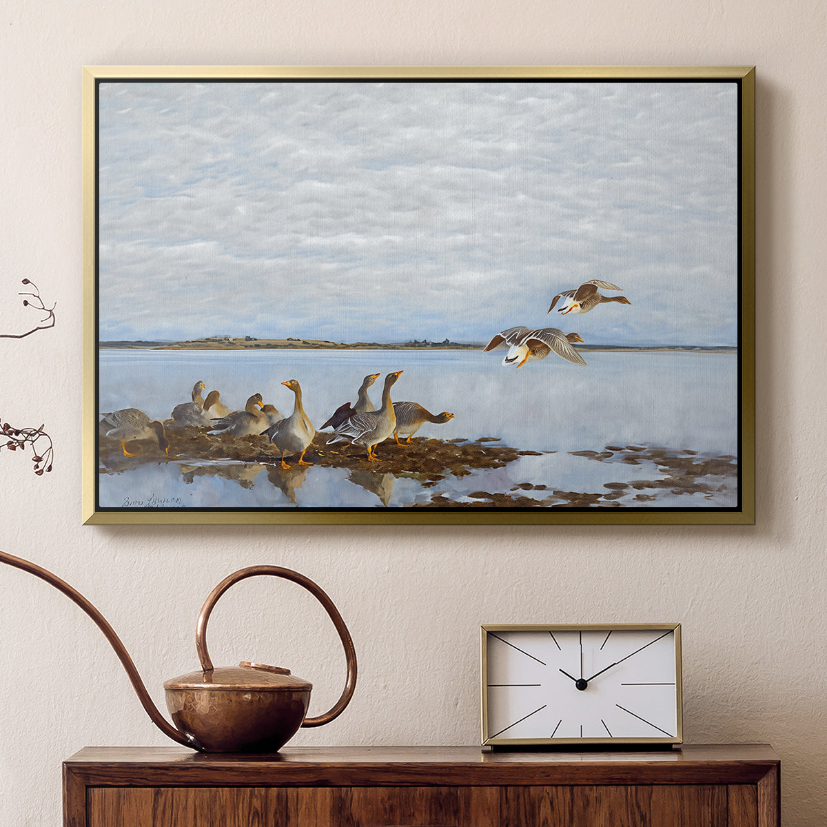 Gold floater framed canvas featuring a realistic wildlife scene of geese in calm outdoor environment, displayed above a cabinet in a soft-toned living room.