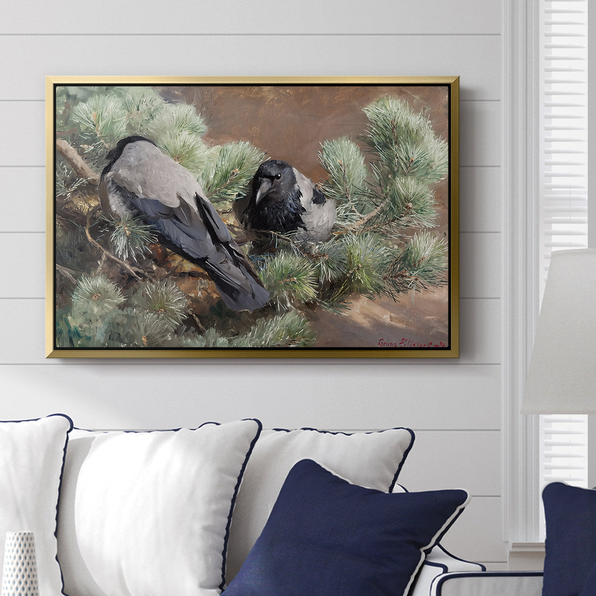 Hooded Crows (Kråkor), 1891 by Bruno Liljefors displayed above a sofa in a living room in a gold floater frame, featuring birds standing alert in natural field environment.