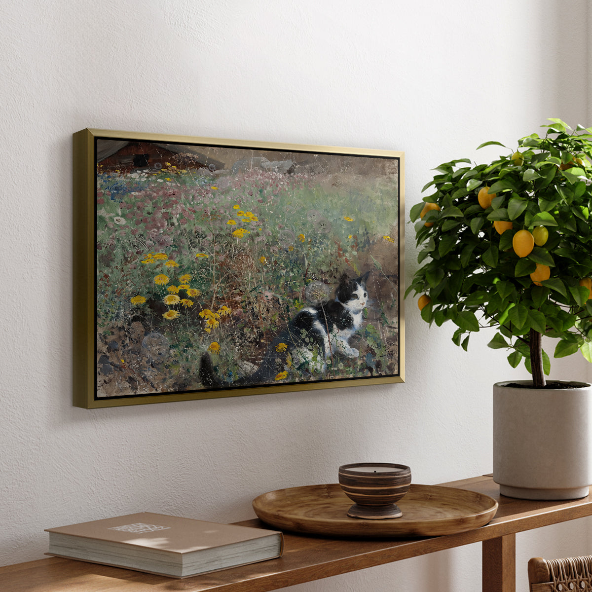 Cat on a Flowery Meadow, 1887 by Bruno Liljefors, presented in a gold floater framed canvas featuring a cat crouching in a meadow filled with wildflowers and greenery, displayed above a hallway console table.