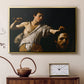 Gold floater framed canvas featuring a Baroque depiction of youth holding severed head in shadowy setting, displayed above a cabinet in a soft-toned living room.