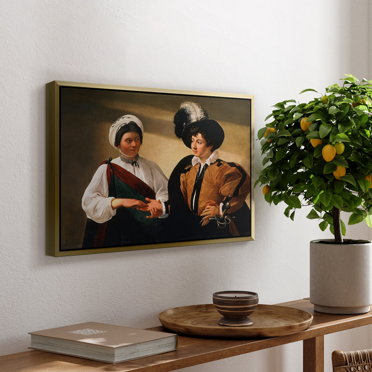 The Fortune Teller (Louvre Version), c. 1595 by Caravaggio, presented in a gold floater framed canvas featuring a woman reading a young man's palm while secretly stealing his ring, displayed above a hallway console table.