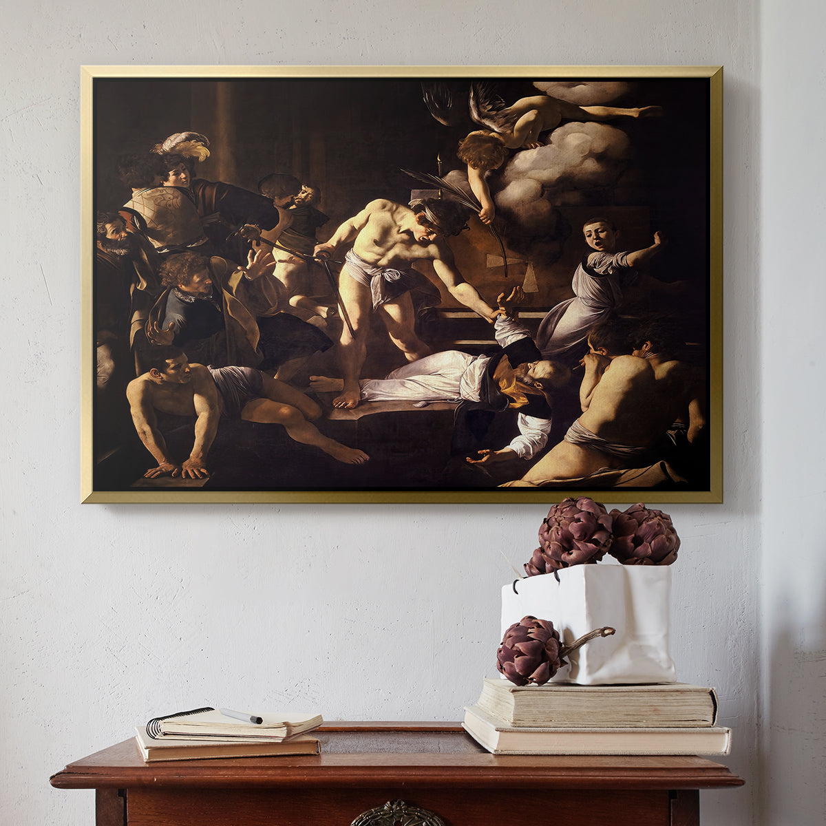 Gold floater framed canvas featuring The Martyrdom of Saint Matthew, 1599-1600 by Caravaggio above an entryway table in a minimalist foyer.