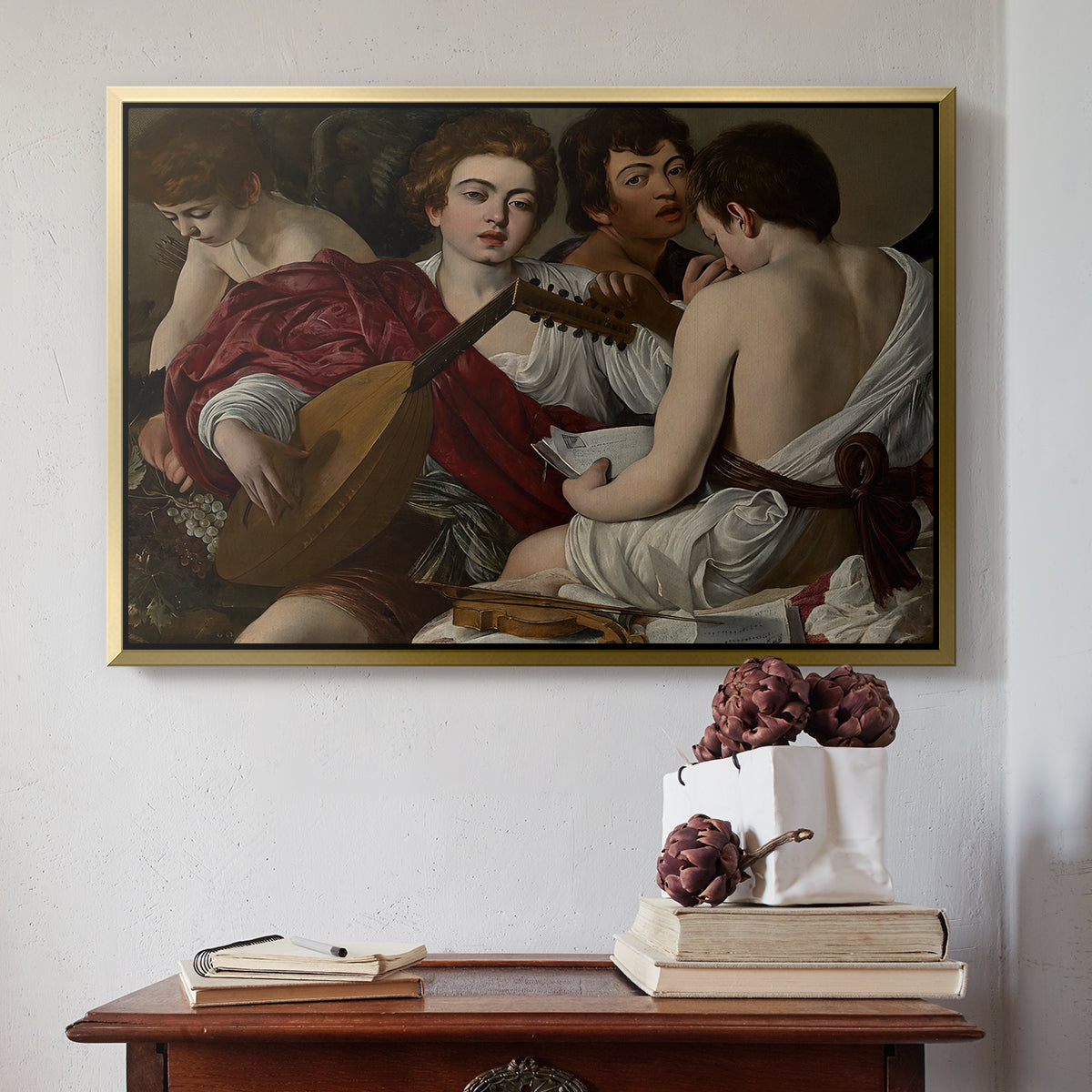 Gold floater framed canvas featuring The Musicians, c. 1595 by Caravaggio above an entryway table in a minimalist foyer.