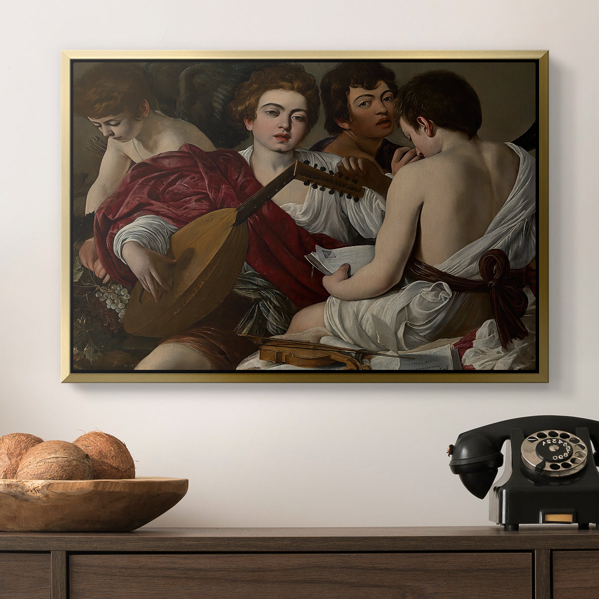 The Musicians, c. 1595 by Caravaggio in a gold floater framed canvas displayed above a console table in a hallway, featuring a musical gathering with figures posed closely in soft light.