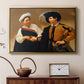 Gold floater framed canvas featuring a close interaction between two figures involving deception and gesture, displayed above a cabinet in a soft-toned living room.