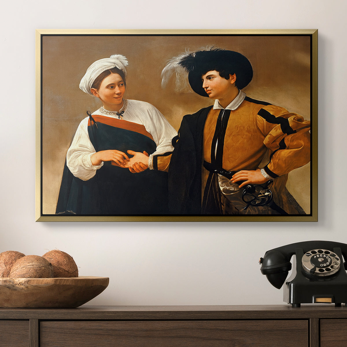 The Fortune Teller (Capitoline Version), c. 1599 by Caravaggio in a gold floater framed canvas displayed above a console table in a hallway, featuring a genre scene of fortune telling with subtle theft.