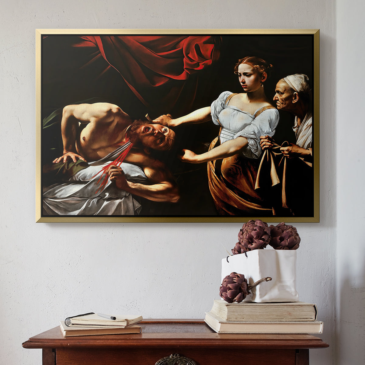 Gold floater framed canvas featuring Judith Beheading Holofernes, c. 1599 by Caravaggio above an entryway table in a minimalist foyer.