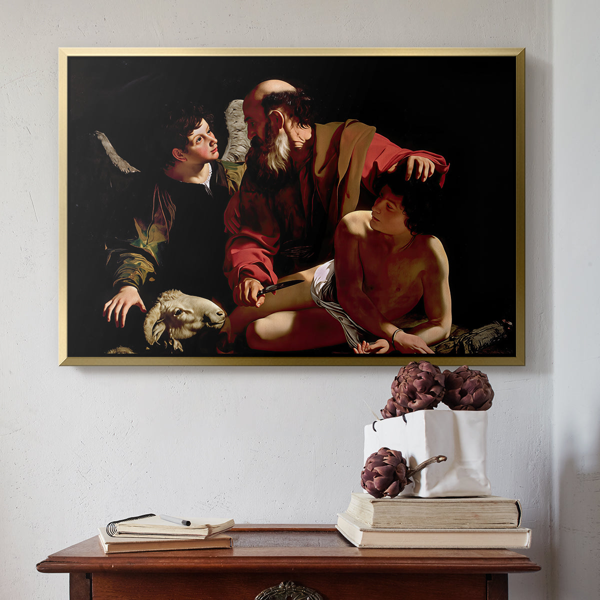 Gold floater framed canvas featuring The Sacrifice of Isaac (Uffizi Version), c. 1603 by Caravaggio above an entryway table in a minimalist foyer.