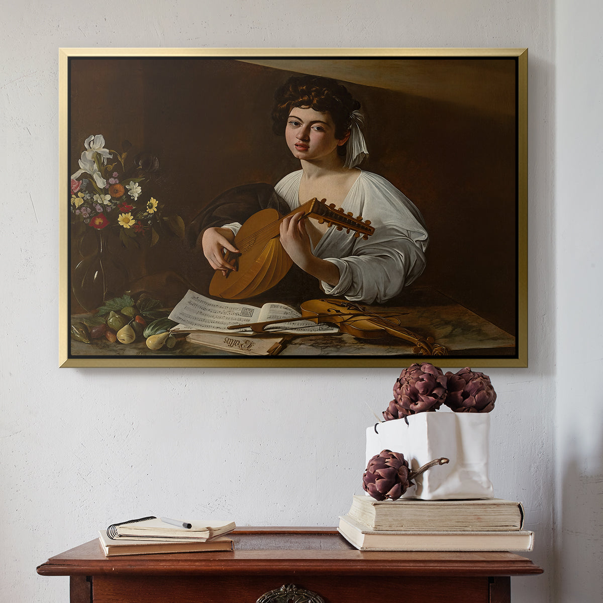 Gold floater framed canvas featuring The Lute Player (Hermitage Version), c. 1596 by Caravaggio above an entryway table in a minimalist foyer.