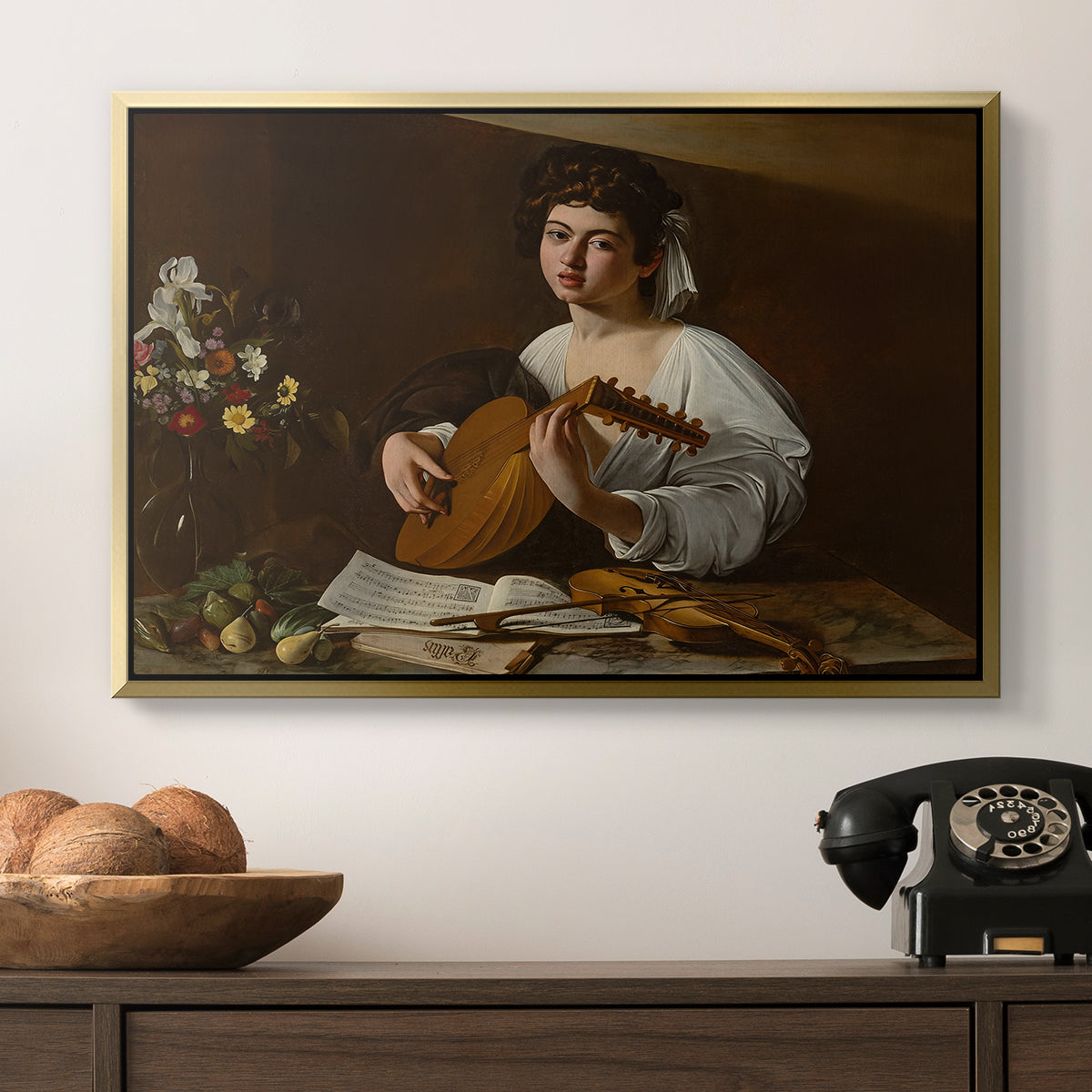 The Lute Player (Hermitage Version), c. 1596 by Caravaggio in a gold floater framed canvas displayed above a console table in a hallway, featuring a Baroque depiction of musician with detailed textures and lighting.